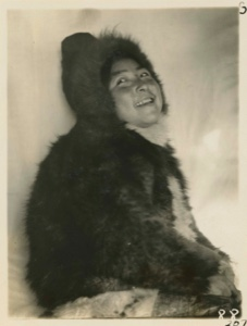 Image of Ahl-ning-wa Head back and laughing. Coat and pants a bluish grey, boots ivory.